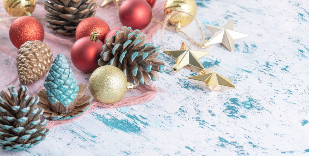 Vielzahl von Christbaumschmuck auf einem Stück Sackleinen auf der blauen Struktur